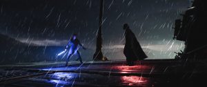 #pracegover audiodescrição resumida: Cena de Star Wars. Chuva. Do lado esquerdo, Luke Skywalker segurando um sabre de luz azul. Do lado direito, Darth Vader. No chão ao lado dele reflete uma luz vermelha.